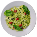 Bow Tie pesto salad with cherry tomatoes on a white round plate