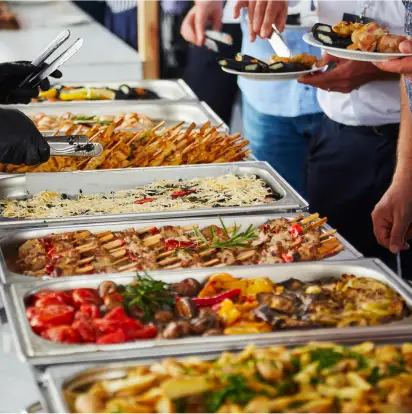a group of people holding plates of mediterranean food