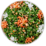 Tabouli Salad a chopped parsley mixed with diced tomatoes and onions in a white bowl