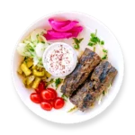 Kafta kabob skewers served over rice with grilled vegetables at Aladdin Mediterranean Cuisine in Houston