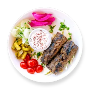 Kafta kabob skewers served over rice with grilled vegetables at Aladdin Mediterranean Cuisine in Houston