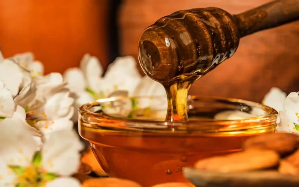 Pure golden honey dripping from a wooden dipper, highlighting the natural sweetness of baclawa