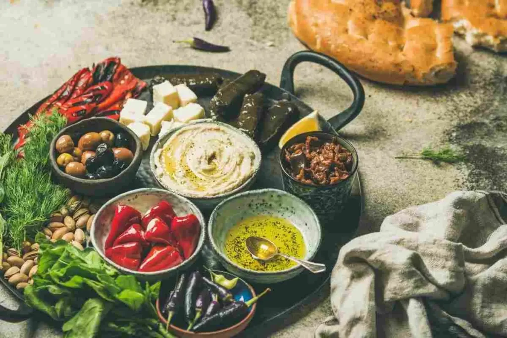 Mezze platter with hummus, olives, stuffed grape leaves, and roasted peppers – Mediterranean cuisine in Houston