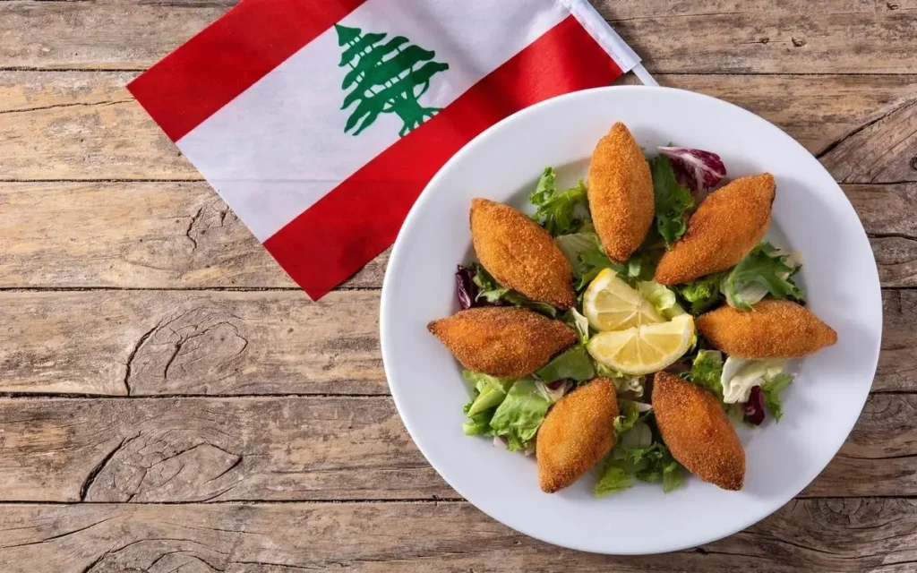 Golden fried kibbeh on a fresh salad with lemon wedges—classic Lebanese cuisine at Aladdin Mediterranean Cuisine, Houston